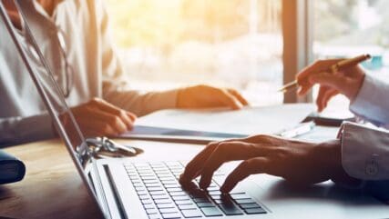 Close up of two people drafting a will at a desk