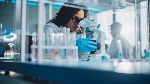 Woman in laboratory looking through a microscope