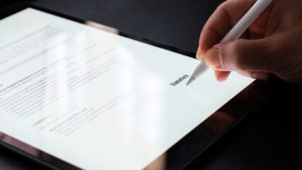 Person Signing SLA Contract On Digital Tablet