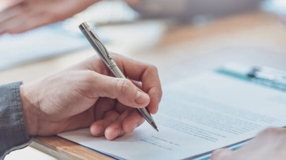 Close up of a hand signing an ATED return.