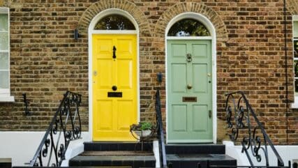 Two coloured doors on the front of a brick property