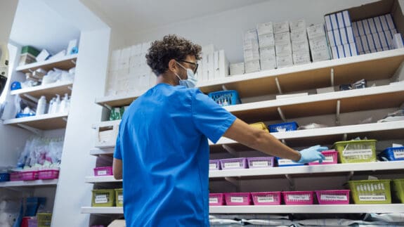 Pharmacist taking medication from a shelf