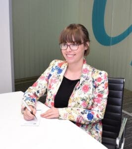 Fiona Jobson sitting at a desk in Cambridge office smiling