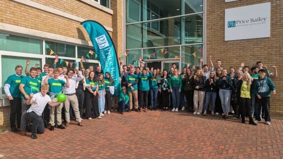 Price bailey staff standing outside Cambridge office cheering in support of Samaritans charity