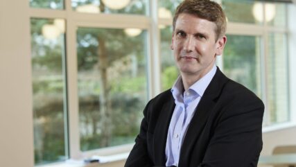 Jon Chambers standing in Cambridge office with arms folded