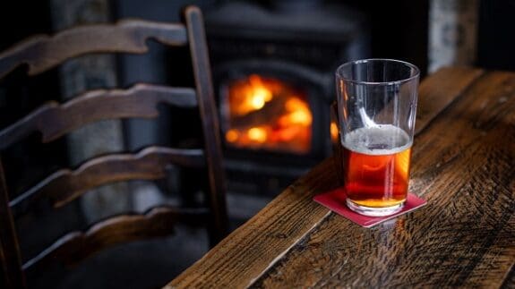 Half Full Pint of Beer on a Wooden Table