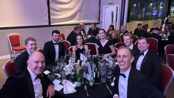 Price Bailey SCF team celebrate sitting at table celebrating award win