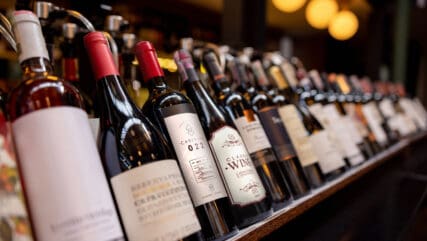 Close-up on bottles of wine displayed on the rack at a winery