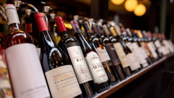 Close-up on bottles of wine displayed on the rack at a winery